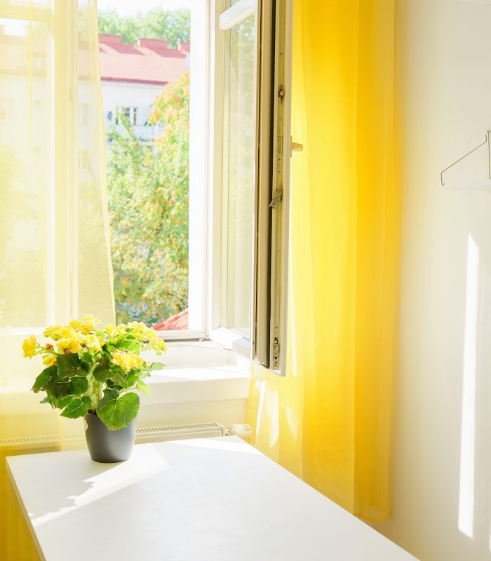 Modern kitchen interior with large window and yellow curtains Window at the kitchen with bright yellow curtains. Positive colors. Illuminating yellow. Stress reducing concept. Comfort zone. Interiors